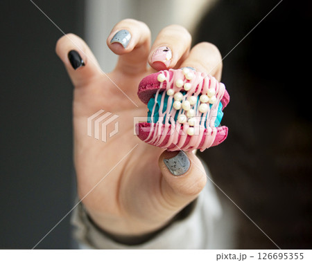 Female hands holding colorful french macaroons Female hands holding colorful french macaroons 126695355