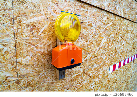 Construction Warning Light Mounted on OSB Panel with Barrier Stripe 126695466