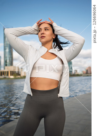 Sporty Woman Stretching Outdoors by the City Waterfront at Sunrise Sporty Woman Stretching Outdoors by the City Waterfront at Sunrise 126696064