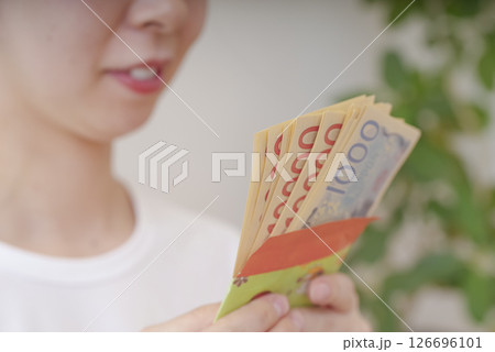 お金を数える若い女性 126696101