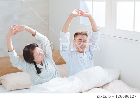 起床して伸びをするシニア夫婦 起床して伸びをするシニア夫婦 126696127