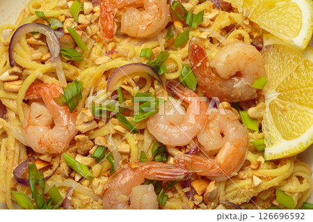 Pad thai noodles with shrimps, peanuts, green onions and lemon slice close up Pad thai noodles with shrimps, peanuts, green onions and lemon slice close up 126696592