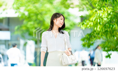 夏の屋外を歩く笑顔の女性・ビジネスウーマン 126697623