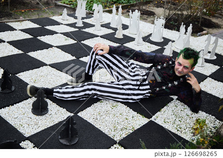 An Eccentric and Vibrant Chessboard Scene Featuring a Unique Character and Giant Game Pieces An Eccentric and Vibrant Chessboard Scene Featuring a Unique Character and Giant Game Pieces 126698265