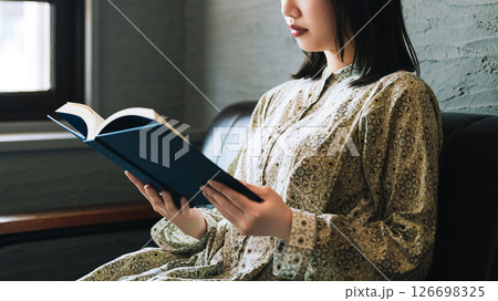 ソファに座って読書をする女性 ソファに座って読書をする女性 126698325