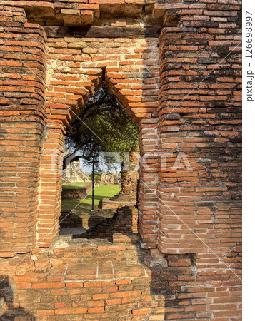 Historic remains of a Buddhist temple stand in peaceful silence in Thailand, showcasing traditional sacred architecture and cultural heritage. Wat Maha That offers a spiritual retreat. 126698997