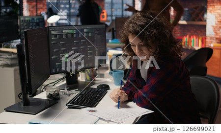 Tech startup HR employee analyzing candidates for job opening, reviewing resumes to determine skills. Woman screening people for software development Silicon Valley company position, camera A 126699021