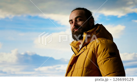 Male explorer embraces the solitude of high altitude wilderness, climbing on top of the mountain for fresh air and a scenic background. Mindfulness and relaxation in the nature. Camera B. Male explorer embraces the solitude of high altitude wilderness, climbing on top of the mountain for fresh air and a scenic background. Mindfulness and relaxation in the nature. Camera B. 126699129