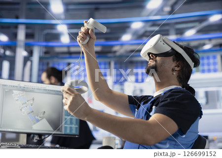 Photovoltaics factory professional using VR gear to do performance testing of solar panel designs. Staff member improving solar panel configurations for cost reduction using virtual reality technology 126699152
