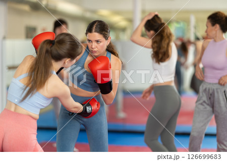 Women in boxing gloves practice boxing techniques 126699683