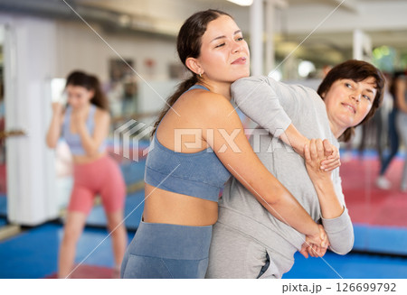 Women in pair perform effective impact on pain points while learning self-defense. Women in pair perform effective impact on pain points while learning self-defense. 126699792