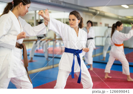 Women pupils train to perform defensive karate installations and attacking combat techniques Women pupils train to perform defensive karate installations and attacking combat techniques 126699841