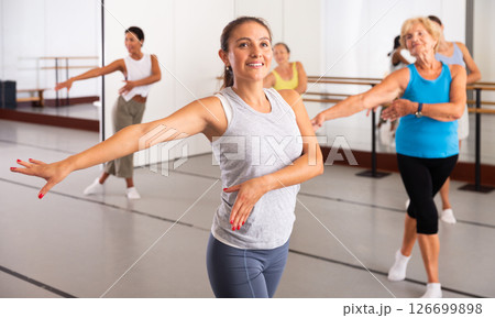 Latino girl dancing modern dance in studio with other dancers 126699898