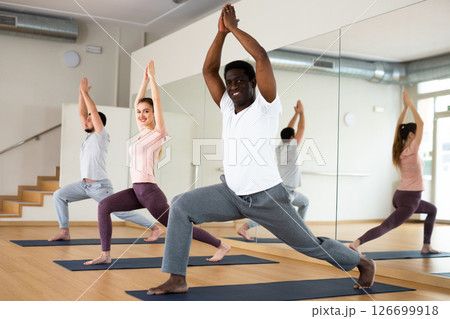 African american standing in Ashta Chandrasana with hands in prayer above head African american standing in Ashta Chandrasana with hands in prayer above head 126699918