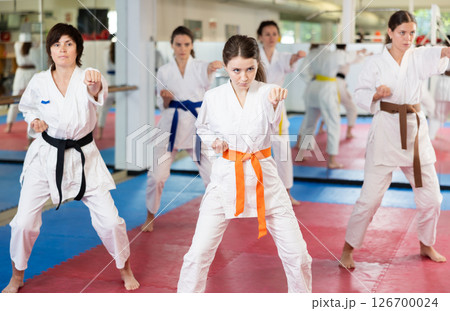 Group of women training karate techniques in studio Group of women training karate techniques in studio 126700024