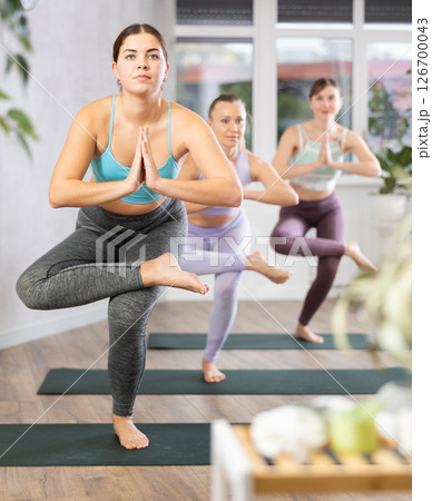 Three women doing yoga in fitness studio 126700043