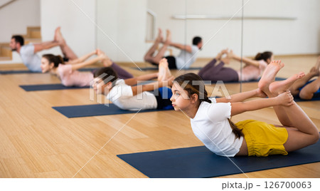 Girl practicing yoga at studio with family Girl practicing yoga at studio with family 126700063