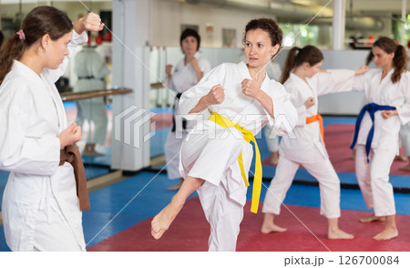 Women practice karate techniques in pairs 126700084