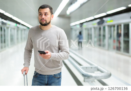 Portrait of confident man traveling on subway and using smartphone Portrait of confident man traveling on subway and using smartphone 126700136