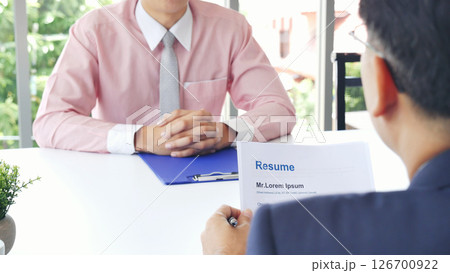 Businessman job interview by human resource HR officer interviwing, talk new employee shaking hands in office with smiling face. HR Manager interview check resume, face to face. Job Interview Concept Businessman job interview by human resource HR officer interviwing, talk new employee shaking hands in office with smiling face. HR Manager interview check resume, face to face. Job Interview Concept 126700922