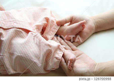 赤ちゃんの小さな足とママの手 126700998