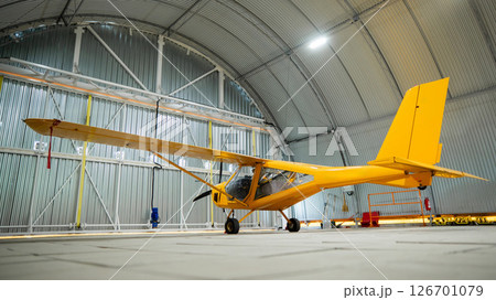 Yellow airplane glider in the hangar. Yellow airplane glider in the hangar. 126701079