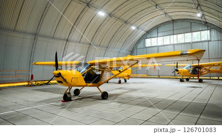 Yellow airplane glider in the hangar.  126701083