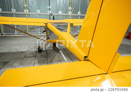 Yellow airplane glider in the hangar.  126701098