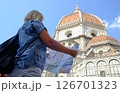 A woman with a backpack holds a card in her hands 126701323
