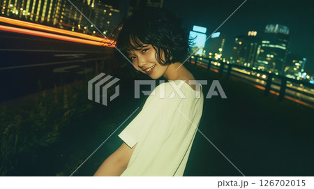 夜の都会を歩く若い女性 126702015