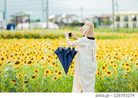 <安曇野>新村ひまわり畑を楽しむ女性の後ろ姿 <安曇野>新村ひまわり畑を楽しむ女性の後ろ姿 126703274