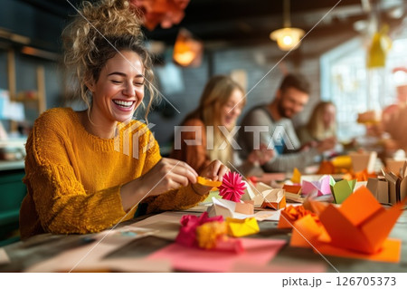 Group of diverse people enjoy creative paper crafts in a cozy workshop environment 126705373