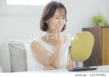 リビングで鏡を見るミドル女性 126707862