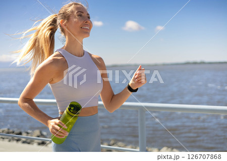 Sport woman morning running jogging on city river embankment side view 126707868