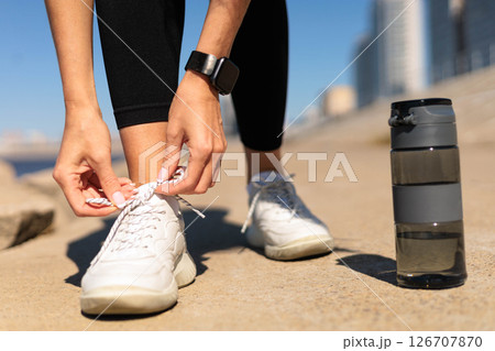 Woman runner jogger hands tying shoelace on sneakers enjoy outdoor activity closeup Woman runner jogger hands tying shoelace on sneakers enjoy outdoor activity closeup 126707870