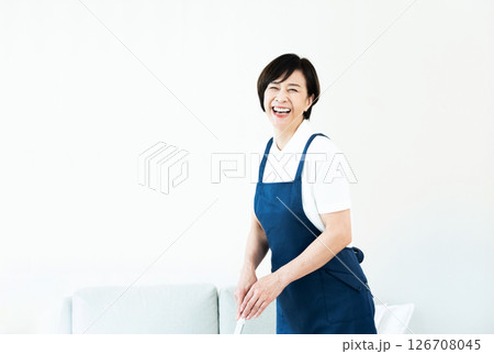 リビングの掃除をするエプロン姿の女性 リビングの掃除をするエプロン姿の女性 126708045