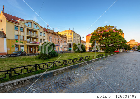 uzhhorod, ukraine - 04 jun 2017: koriatovycha square in morning light. cobblestone street of the old town. capital of transcarpathia. cloudless peaceful blue sky in summer uzhhorod, ukraine - 04 jun 2017: koriatovycha square in morning light. cobblestone street of the old town. capital of transcarpathia. cloudless peaceful blue sky in summer 126708408