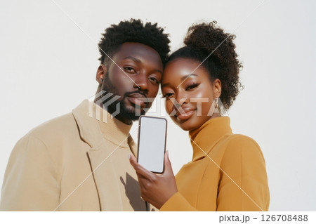A man and a woman are holding a cell phone together 126708488