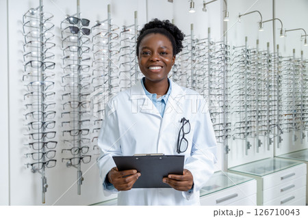 Female african american optician in a lab coat looking contented and positive 126710043