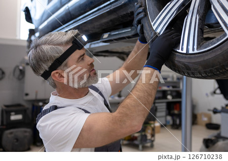 Mechanic inspecting wheel Mechanic inspecting wheel 126710238