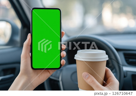 Person holding smartphone with green screen and coffee cup inside car. Mockup for app, navigation or mobile ads. Modern lifestyle, driving, technology and coffee break concept. Copy space. Banner 126710647