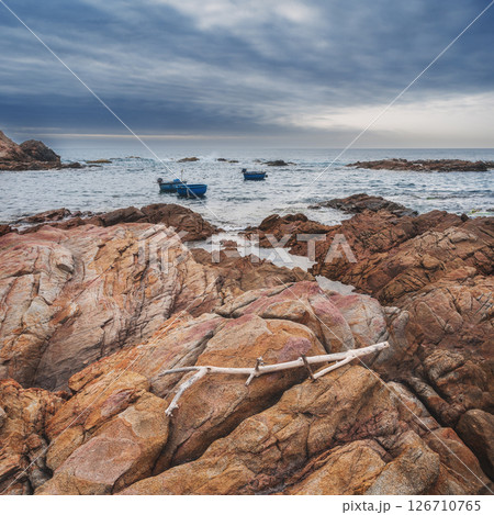 Seascape with Vietnamese round basket boats floating in sea next to the rocks 126710765