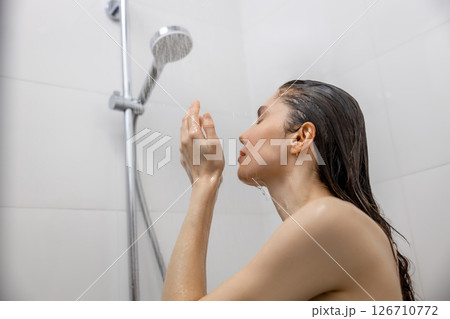 Woman showering in bathroom washing hair enjoying healthy skincare and hygiene time Woman showering in bathroom washing hair enjoying healthy skincare and hygiene time 126710772