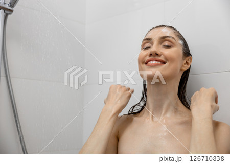 Brown haired woman bathing in shower with gel in bathroom washing hair relaxing at home 126710838