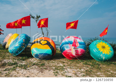 beautiful painted round traditional Vietnamese boats Thung Chai and flag of Vietnam in Murals Fishing Village in Tam Thanh beautiful painted round traditional Vietnamese boats Thung Chai and flag of Vietnam in Murals Fishing Village in Tam Thanh 126710850