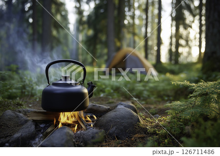 A simple morning moment with a metal kettle on fire and tent behind. Peaceful, minimal, eco-friendly glamping lifestyle. 126711486
