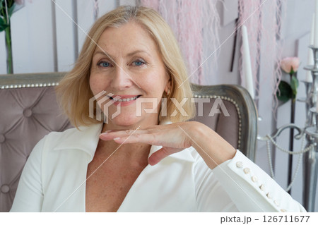 A woman is using a Gua Sha tool for a facial massage, promoting relaxation and enhancing her beauty routine 126711677