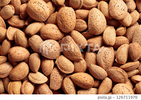 Background of big raw unpeeled almonds situated arbitrarily. 126711970
