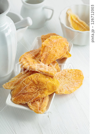 Dried mango slices on a white table. Dried mango slices on a white table. 126712003