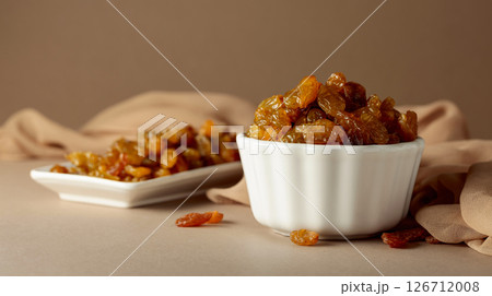 Yellow sultana raisins in a white bowl. Yellow sultana raisins in a white bowl. 126712008
